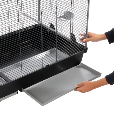 Bird cage with pull-out plastic tray for easy cleaning, shown with hands pulling out the tray.