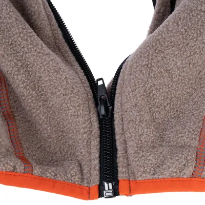 Gros plan sur un tissu polaire marron avec fermeture éclair noire et coutures orange.