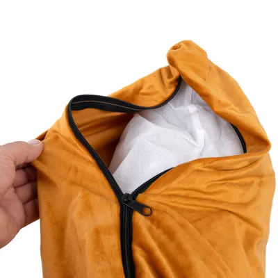 Nahaufnahme eines orangefarbenen Bezugs mit Reissverschluss, geöffnet, zeigt weissen Innenstoff. Hand hält den Bezug.