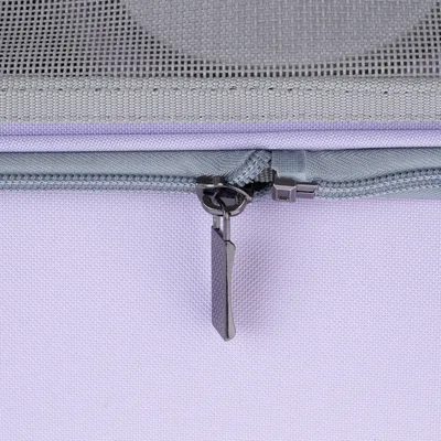 Gros plan sur une fermeture éclair grise en métal sur tissu violet, avec partie supérieure en maille synthétique grise.