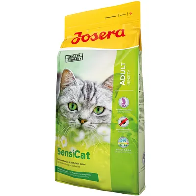 Опаковка Josera SensiCat Adult Sensitive за котки, надпис Made in Germany, икони: лесно смилаема, анти-космени топки, pH 6,0–6,5. Снимка на сива котка отпред.