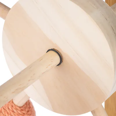 Gros plan sur une structure en bois clair avec tige ronde et disque, détail d’un jouet ou accessoire pour animaux. Matériau visible : bois.