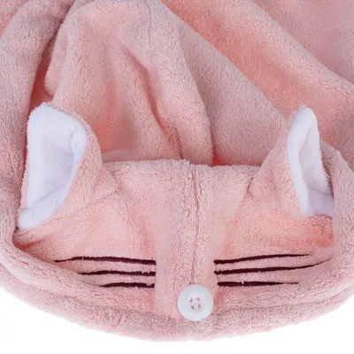 Roze stof met kattenoren, knoopsluiting en geborduurde snorharen. Zacht materiaal zichtbaar.