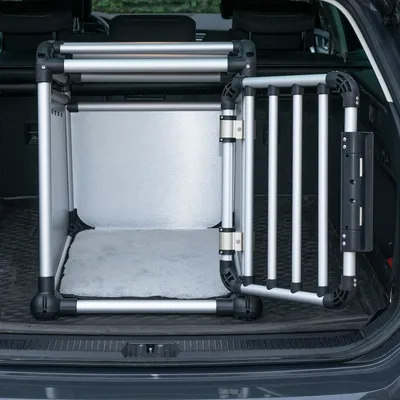 Transportbox aus Aluminium und Kunststoff mit Gittertür, geeignet für den Kofferraum. Innen mit weisser Matte ausgelegt.