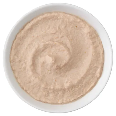 Primer plano de un cuenco con textura cremosa de color beige. La imagen del producto muestra la textura del contenido.