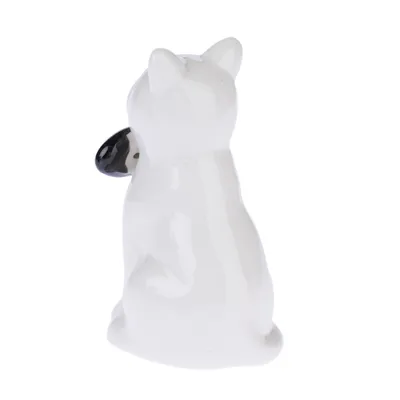 Figurine en céramique blanche représentant un chien assis, vue de dos, avec museau noir visible sur le côté.