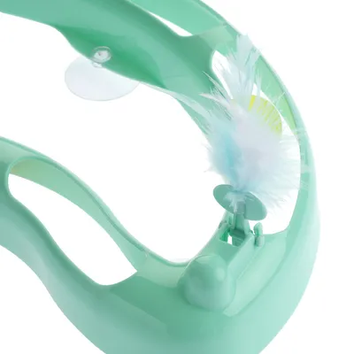 Jucărie din plastic verde cu arc integrat alb și albastru, atașată de un suport.