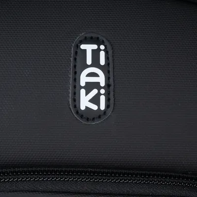 Tiaki. Logotip marke na crnom materijalu s vidljivim patentnim zatvaračem.