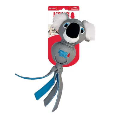 KONG Wubba gioco a forma di koala con corpo in tessuto grigio, nastri blu e orecchie in peluche. Confezione con scritte 'Squeaks' e 'Jouet Couineur'.