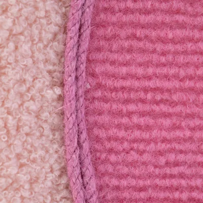 Krupni plan dvije vrste tkanine: lijevo krem pliš, desno ružičasta rebrasta tkanina s ružičastim užetom između.