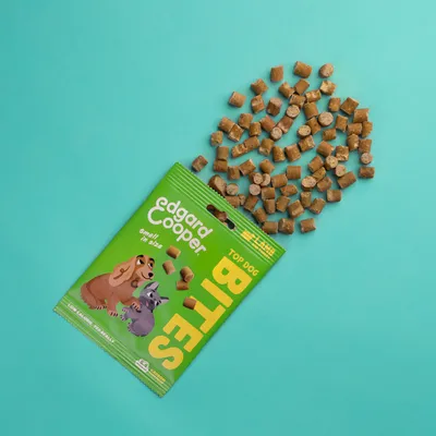 Edgard Cooper Top Dog Bites, groene verpakking met cartoonhond en kat, tekst: 'small in size', brokjes zichtbaar uitgestrooid. Lage calorieën, 125 treats per zak.