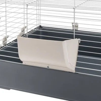 Vista interna di una gabbia per piccoli animali con mangiatoia in plastica beige fissata alle sbarre metalliche e fondo in plastica nera.