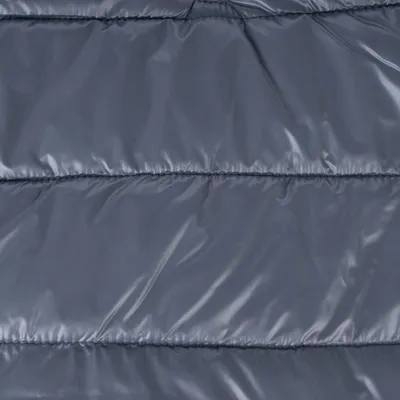 Gros plan sur tissu matelassé gris, aspect lisse et brillant, coutures horizontales visibles. Matériau synthétique apparent.