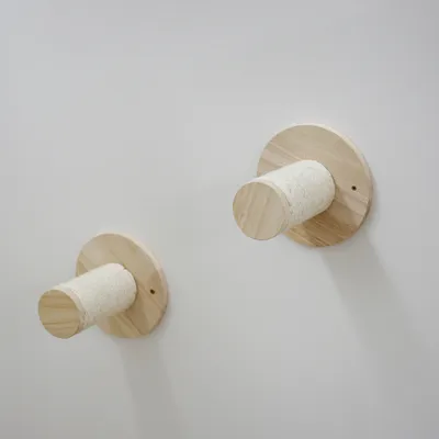 Two wooden wall mounts with cylindrical elements, partially wrapped with sisal rope. Suitable for scratching or climbing purposes.