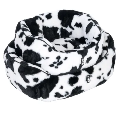 Black and white pet bed with cowhide pattern, two stackable sizes, Trixie brand visible on both beds.