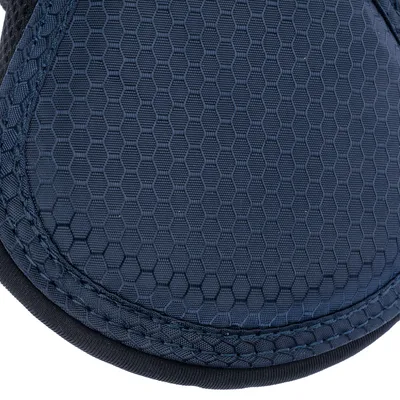 Gros plan sur une surface en tissu bleu à motif hexagonal, avec coutures visibles sur le bord. Matériau textile apparent, aucun texte ou marque visible.