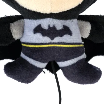 Plush toy in Batman design with black bat symbol on grey background and yellow belt.
