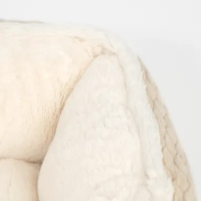 Nahaufnahme von weichem, cremefarbenem Plüschmaterial, geeignet für Haustierprodukte wie Betten oder Decken.