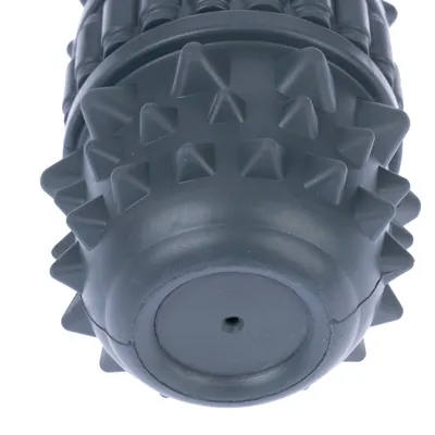 Jouet cylindrique gris en caoutchouc avec picots pyramidaux sur toute la surface, extrémités arrondies et petit trou visible à une extrémité.