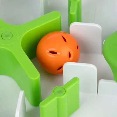 Lelu, jossa vihreä labyrintti ja oranssi pallo, sopii interaktiiviseen leikkiin.