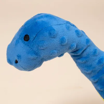 Plavi plišani igračka u obliku glave dinosaura s točkastom teksturom i crnim očima.