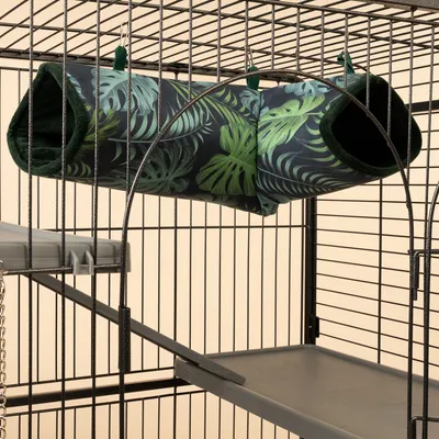 Túnel colgante con estampado de hojas tropicales, fijado a jaula metálica. Adecuado como refugio para pequeños animales.