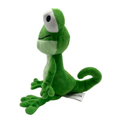 Grünes Plüschspielzeug in Form eines Frosches mit grossen Augen und einem weissen Etikett an der Seite.