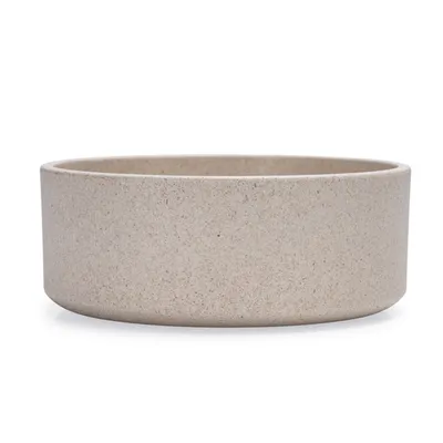 Gamelle ronde beige en céramique sans marque visible, surface lisse, bord droit, sans décorations ni texte apparent.