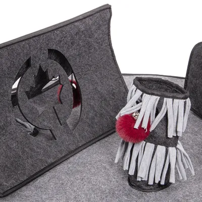 Grey felt toy with a leaf-shaped cut-out and a cylindrical play module with tassels and a red plush ball. Suitable for interactive play.