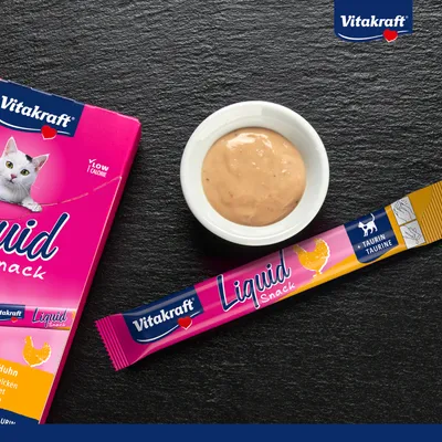 Vitakraft Liquid Snack con pollo y taurina, bajo en calorías. Envase y monodosis junto a cuenco con contenido cremoso.