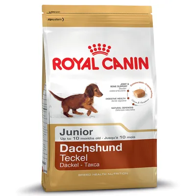 Bag labelled Royal Canin Junior Dachshund, up to 10 months old. Highlights joint and bone support, digestive health, natural defences, exclusive kibble shape, calcium and phosphorus.