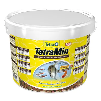 Envase de alimento para peces tropicales TetraMin, texto visible: 'Complete food for all tropical fish', 'BioActive', 'For health, colour and vitality', 'Biologically balanced'.