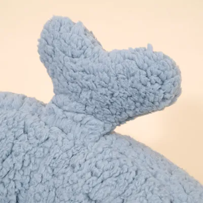 Detailansicht eines hellblauen, flauschigen Stoffteils mit einer abstehenden Form, Material wirkt weich und plüschig.