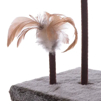 Close-up of a cat tree base with a brown post and attached feather toy. Feathers are light brown and white, fixed to the top of a short post on a grey faux fur platform.