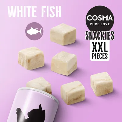 COSMA PURE LOVE SNACKIES XXL PIECES, WHITE FISH. Kostky bílého rybího masa a část obalu s černou siluetou kočky na růžovém pozadí.