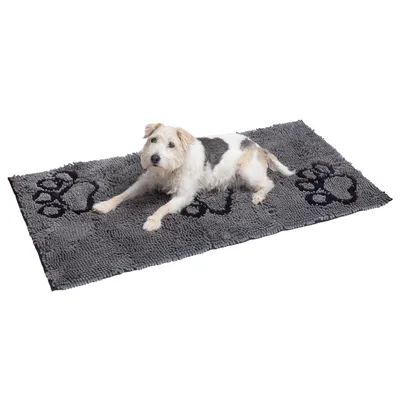 Grå hundmatta med svarta tassavtryck, en vit-svart hund ligger på den. Matta av mjukt material för husdjur.
