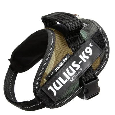 Hundesele med tekst: JULIUS-K9, IDC by JULIUS-K9, IDC®POWER. Selen har sort spænde og håndtag, camouflagefarvet stof og synlige syninger.