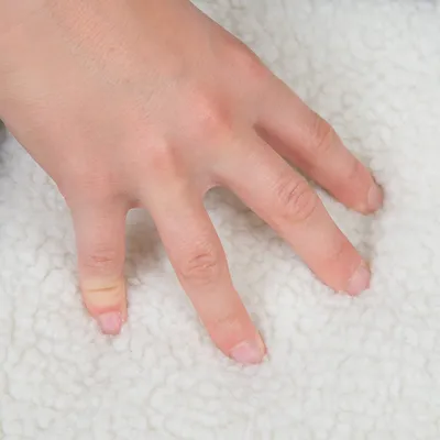 Hand drukt op zacht, wit materiaal dat gemakkelijk in te drukken is. Weergave van textuur en comfort van het product.