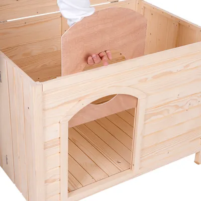 Niche en bois clair avec cloison amovible, main tenant la cloison par une ouverture ronde. Bois visible sur toutes les faces intérieures et extérieures.