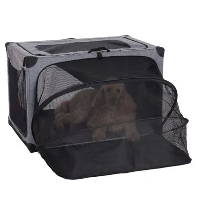 Transportbox aus grauem Stoff mit schwarzem Netz, geöffnet. Hund liegt innen sichtbar durch das Netz.