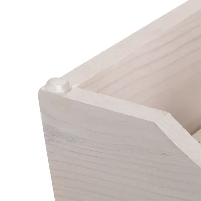 Corner of a wooden structure with visible grain and plastic protective cap on the upper corner.