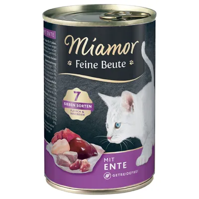 Miamor Feine Beute -kissanruokapurkki, näkyvissä tekstit: 7 Sieben Sorten Fleisch & Innereien, mit Ente, getreidefrei. Kuvassa valkoinen kissa ja erilaisia lihapaloja.