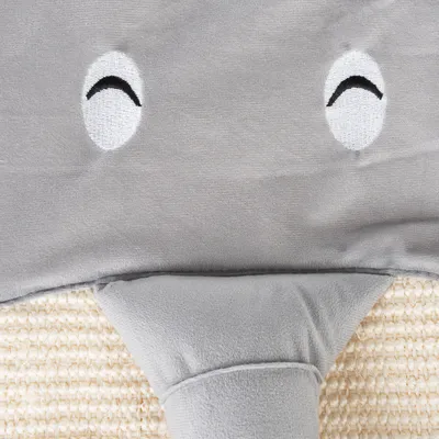 Graues Plüschmaterial mit gestickten Augen und einem Rüssel, Teil eines Elefanten-Designs auf einer beige gewebten Unterlage.