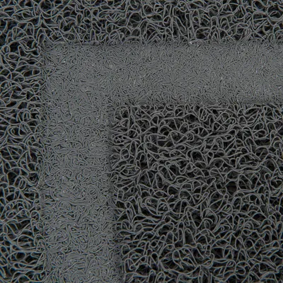 Nahaufnahme einer grauen, strukturierten Oberfläche mit verschlungenen Fasern. Materialdetails sichtbar.
