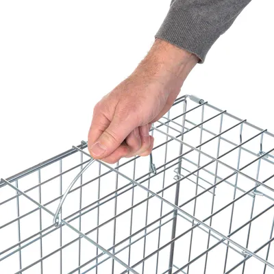 Käsi avaa metalliritilän lankalukon, näyttää lukitusmekanismin käytön.
