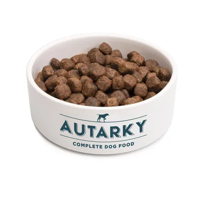 Bowl filled with brown kibble, labelled 'Autarky Complete Dog Food'.