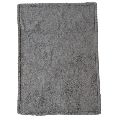Tapis rectangulaire gris en tissu à surface douce, sans motifs ni texte visible.