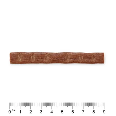 Brun tyggegodt i stangform, længde ca. 9 cm, med måleskala til størrelsesangivelse.
