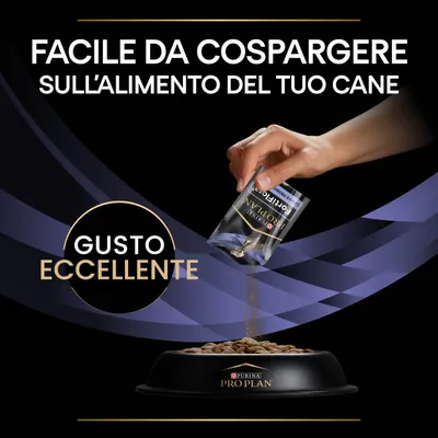 Testo: Facile da cospargere sull'alimento del tuo cane. Gusto eccellente. Mano versa Purina Pro Plan FortiFlora su crocchette in ciotola nera Purina Pro Plan.