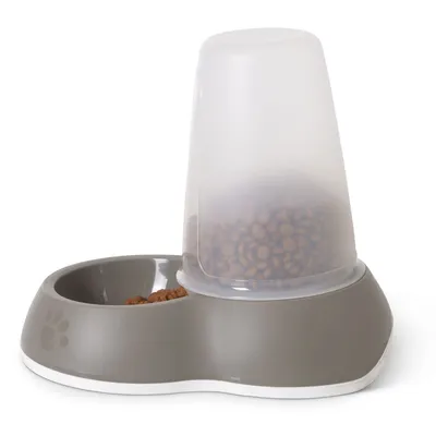 Harmaa muovinen automaattiruokinta-astia, jossa läpinäkyvä säiliö täynnä kuivaruokaa ja erillinen ruokakuppi. Astian kyljessä tassun kuvio.